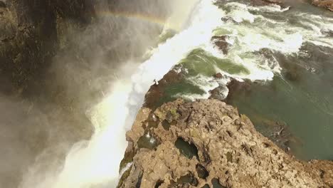 Una-Vista-Aérea-Muestra-A-Un-Turista-En-La-Cima-De-Las-Cataratas-Victoria-En-La-Piscina-Del-Diablo-En-Zambia