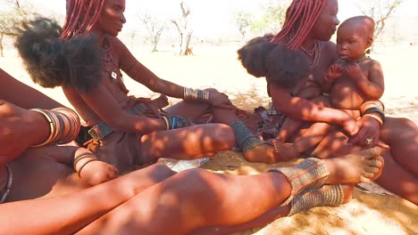 Himba-Stammesfrauen-Mit-Babys-Zeigen-Ihre-Schlammhaarverlängerungen-Und-Ungewöhnlichen-Geflochtenen-Dreadlock-Frisuren-1