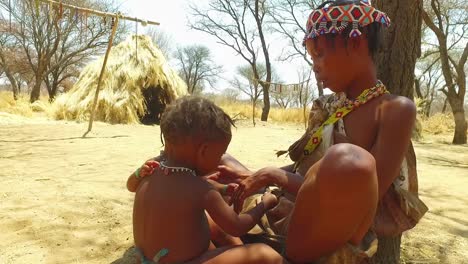 African-San-tribal-woman-and-her-baby-in-a-small-primitive-village-in-Namibia-Africa