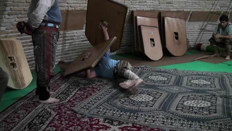 Ein-Mann,-Der-Mit-Einem-Holzschild-Rollt,-Demonstriert-Die-Traditionelle-Iranische-Kampfkunst-Von-Pahlavani
