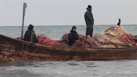 Fishermen-pass-on-a-traditional-style-boat-in-Iran-