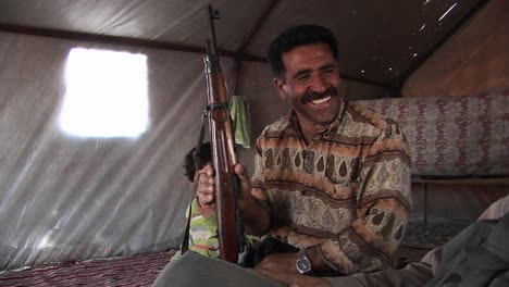 A-man-holds-an-assault-rifle-in-a-tent-in-Iran-