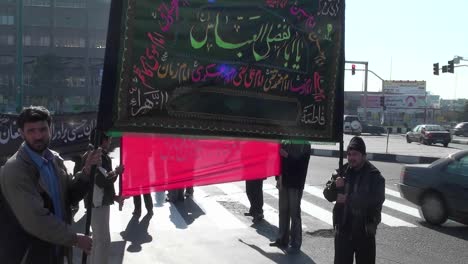 Protesters-hold-a-sign-at-a-busy-intersection-in-Iran-