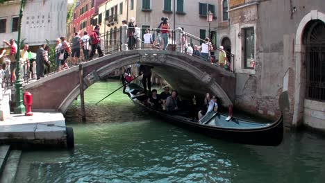 Gondolas-take-people-through-a-narrow-canal-with-buildings-on-each-side-in-Venice-Italy-1