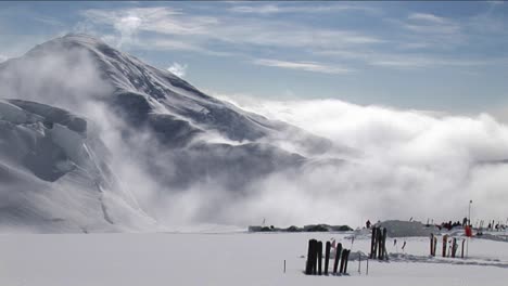 Esquís-En-La-Nieve-Mientras-El-Viento-Sopla-Sobre-El-Pico