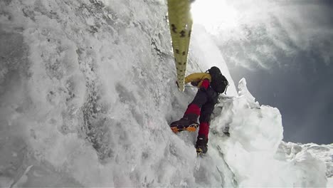 Climber-on-icy-wall-with-wind-and-snow-blowing