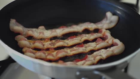 Slices-of-bacon-are-grilled-on-a-skillet