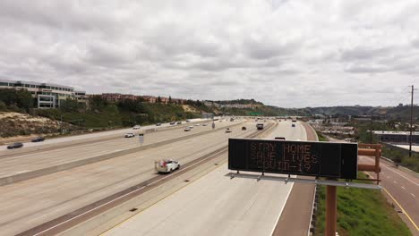 Aerial-sign-along-a-southern-california-freeway-tells-people-to-avoid-travel-during-the-Covid19-coronavirus-epidemic-outbreak