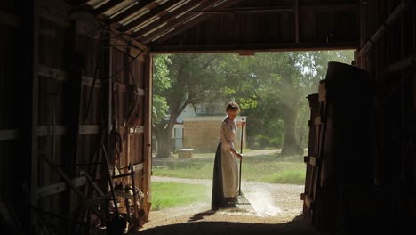 A-Farm-Woman-In-Traditional-Dress-Rakes-Out-A-Barn
