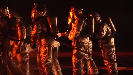 Firemen-In-Hazmat-Or-Heat-Resistant-Suits-Fight-An-Intense-Fire-At-Night-1