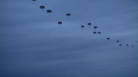Various-Ground-Views-Of-Paratroopers-Jumping-From-Military-Aircraft-At-Night