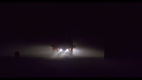 Un-Vehículo-Jeep-Del-Ejército-Estadounidense-Conduce-A-Través-De-La-Niebla-Por-La-Noche.