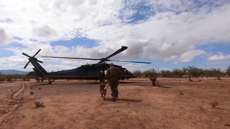 A-Member-Of-The-Us-Border-Patrol-Walks-The-Border-Between-The-Us-And-Mexico-With-A-Dog-Canine-And-Enters-A-Helicopter