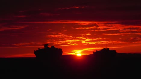 Ein-Konvoi-Von-Uns-Militärfahrzeugen-Panzer-Fährt-Bei-Sonnenuntergang-Oder-Sonnenaufgang-In-Einem-Fremden-Land-In-Dieser-Schönen-Aufnahme