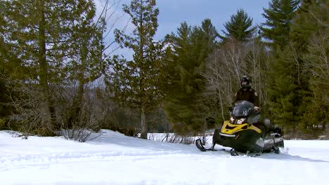 A-Refuge-Law-Enforcement-Officer-Patrols-A-Forest-In-Vermont-On-A-Snowmobile