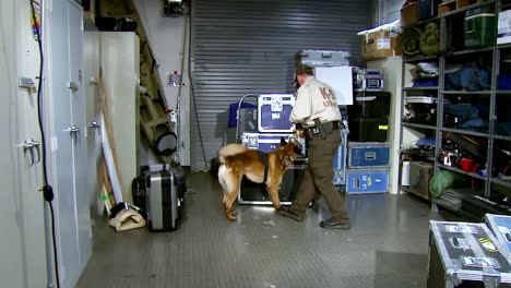 Ein-K9-Hund-Und-Sein-Offizier-Durchsuchen-Einen-Gepäckraum
