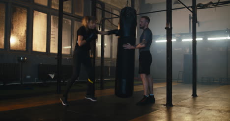 Woman-Boxing-Punching-Bag-with-Trainer