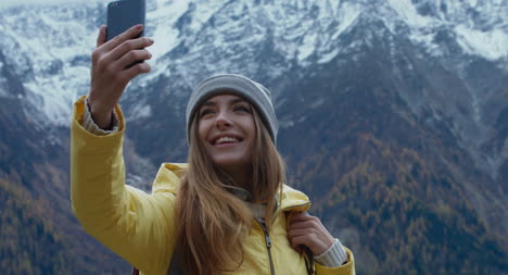 Woman-Taking-Selfie-In-Front-of-Mountains