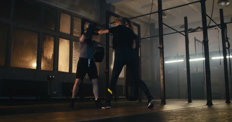 Woman-Boxing-with-Man-Holding-Pads