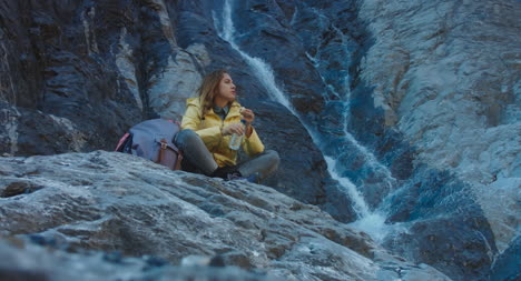 Hiker-Drinking-by-Waterfall