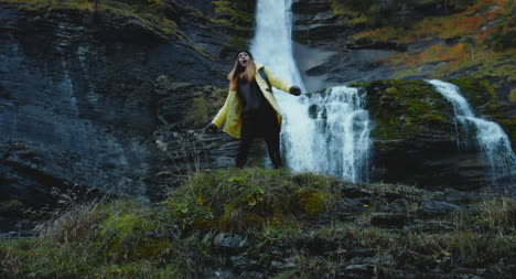 Woman-Dancing-In-Front-of-Waterfall