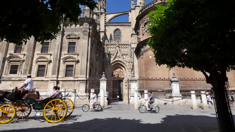 Kathedrale-Von-Sevilla-Mit-Vorbeifahrender-Pferdekutsche