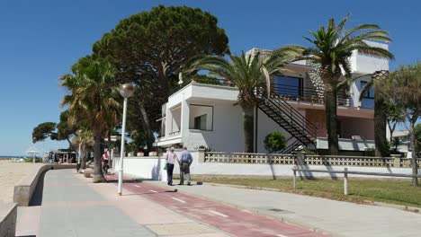 Spain-Cambrils-A-Man-And-Woman-Walk-On-A-Path-Along-The-Beach