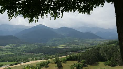Spain-Pyrenees-Leaves-Frame-A-View-Of-Distant-Mountains