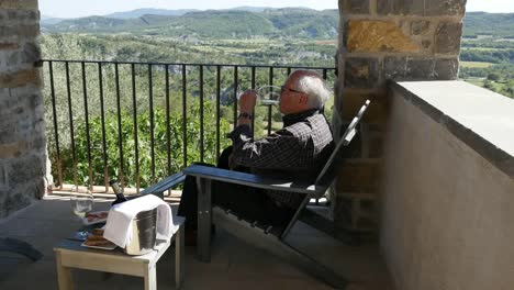 Spain-A-Man-Drinks-Wine-On-A-Balcony-In-The-Spanish-Pyrenees
