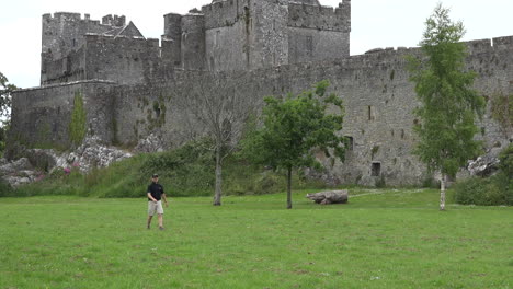 Ireland-Cahir-Castle-With-Man-Playing-Disk-Golf-Zoom-Out