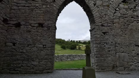 Irland-Corcomroe-Abbey-Landschaft-Jenseits-Von-Kreuz-Und-Gotischem-Bogen