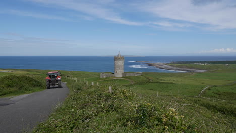 Irland-County-Clare-Doonagore-Castle-Mit-Vorbeifahrendem-Traktor