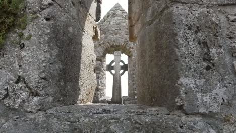 Ireland-Clonmacnoise-A-Celtic-Cross-Is-Seen-Through-A-Stone-Opening-Zoom-In