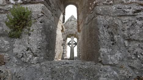 Ireland-Clonmacnoise-A-Celtic-Cross-Is-Seen-Through-A-Stone-Opening