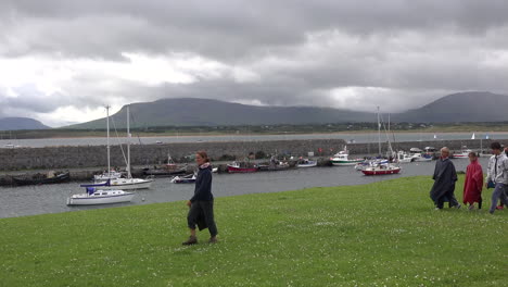 Ireland-Mullaghmore-People-In-Rain-Gear-Pass-A-Boat-Harbor
