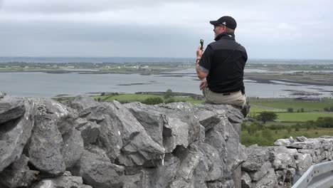 Ireland-Man-On-Stone-Wall-Photographs-With-Phone