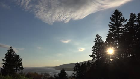 Kanada-New-Brunswick-Sonne-Durch-Bäume-An-Der-Küste-Mit-Wolken