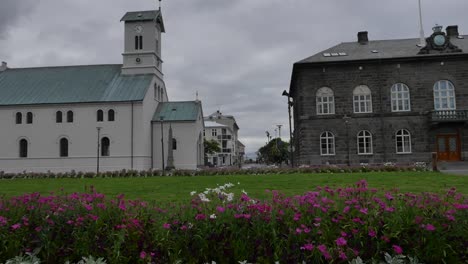 Islandia-Reykjavik-Edificio-De-Piedra-Y-La-Iglesia-Con-Flores.