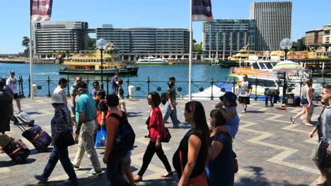 Australia-Sydney-People-Walking-By-Water-As-A-Ferry-Goes-By