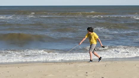 Virginia-Boy-With-A-Stick-Runs-Along-Surf-Line