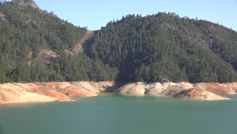 California-Shasta-Lake-With-Low-Water-Level-And-Forest-Above