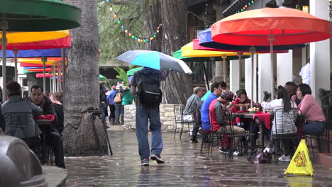 Texas-San-Antonio-Man-With-Umbrella-Walks-Through-Cafe