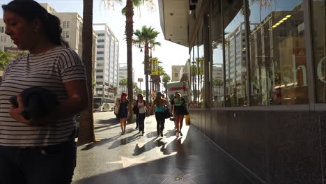 California-A-Backlit-View-Of-People-Walking-Down-A-Hollywood-Sidewalk