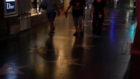 California-People-Walking-Over-Name-Plaques-On-Hollywood-Boulevard-At-Night