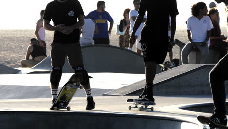 Los-Angeles-Venice-Beach-Skater-Hesitates-Amongst-Others-With-Beach-Beyond