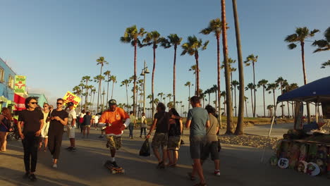 Los-Angeles-Venice-Beach-caminando-por-el-paseo-marítimo-pasado-bicicletas-y-hombre-con-signo