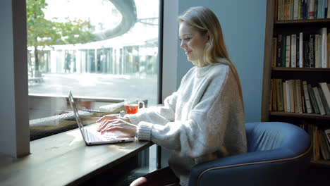 Woman-in-comfortable-armchair-using-laptop