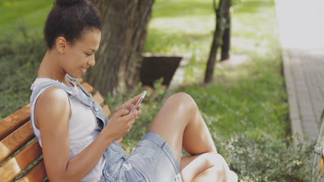 Content-girl-using-smartphone-in-park