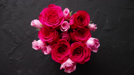 Pink-roses-bouquet-packed-in-red-box-and-placed-on-black-stone-background