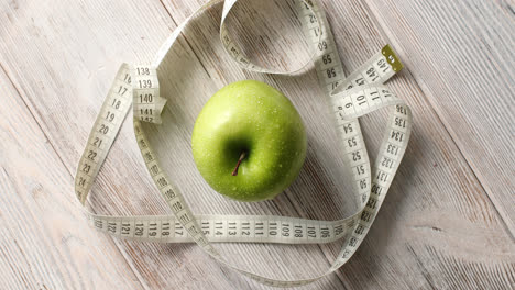 Green-apple-and-measuring-tape-on-table